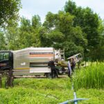 Operatori in un campo che eseguono uno spurgo